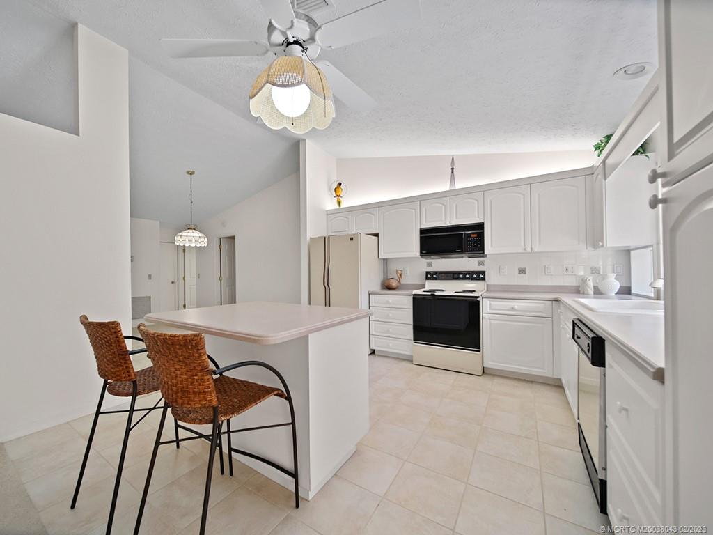 5 Copaire Road Stuart, FL 34996 - Photo 13 of 26 a kitchen with a table chairs microwave and cabinets