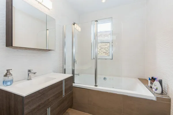a bathroom with a tub sink and a mirror