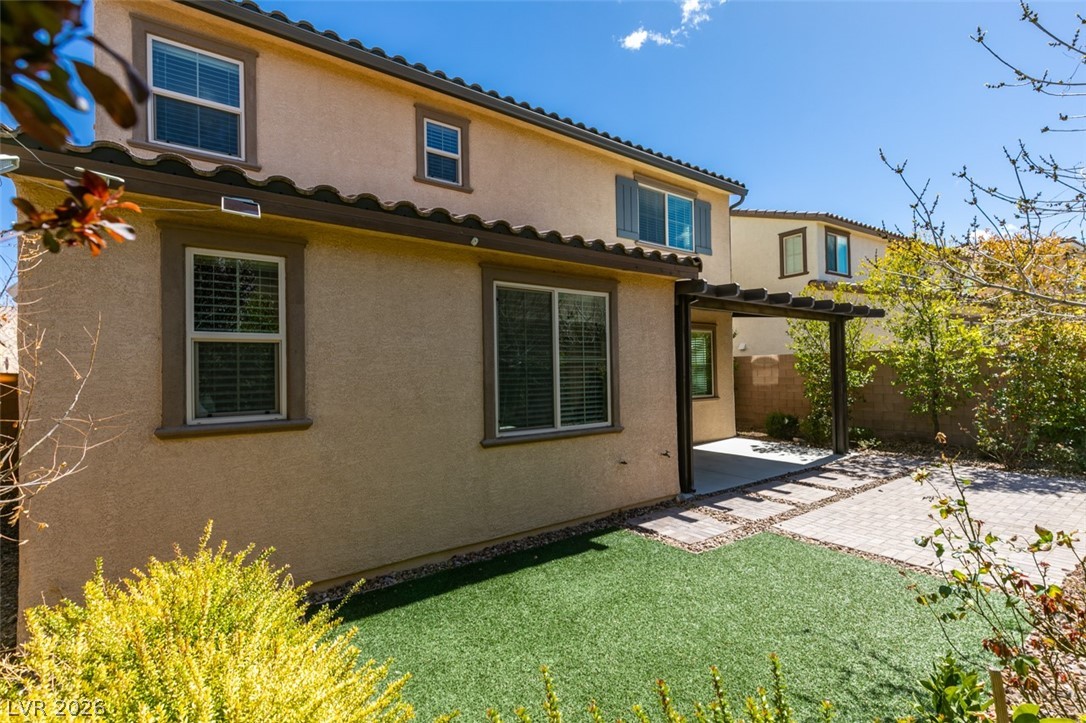 2549 Sable Ridge Street Henderson, NV 89044 - Photo 8 of 8 A private backyard oasis awaits with artificial turf, paved patio, and a shaded pergola for relaxation.