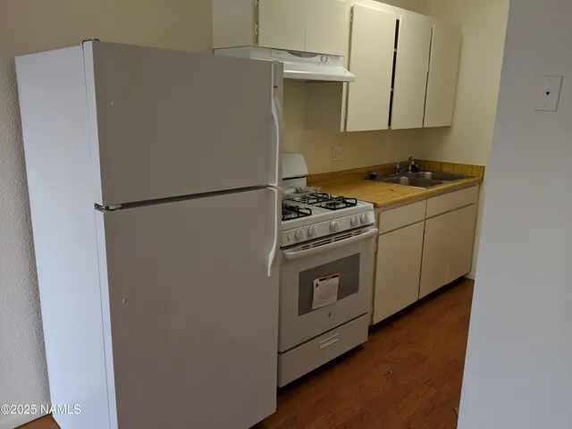 a white refrigerator freezer and a stove sitting inside of a kitchen