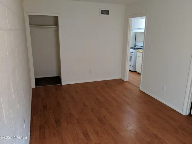 an empty room with wooden floor and closet