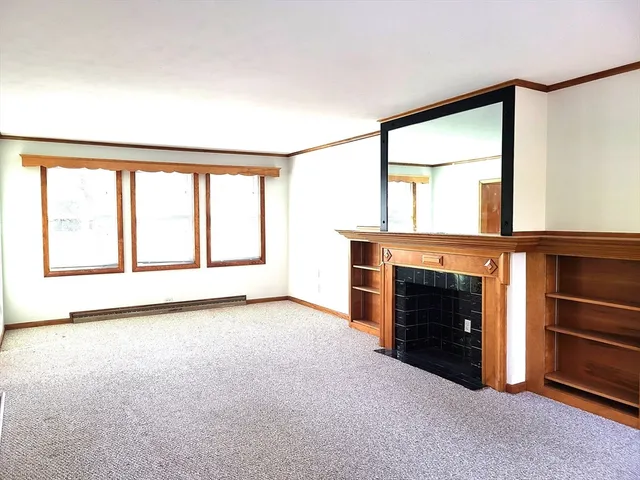 a view of an empty room with a fireplace and a window