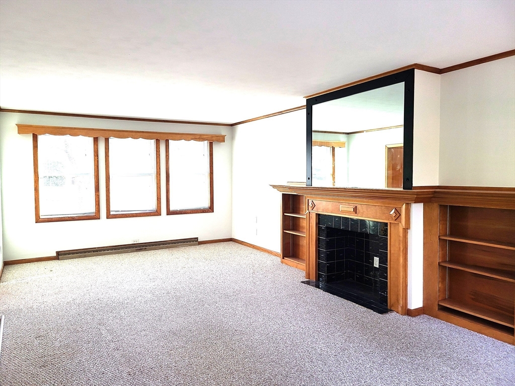 159 Lake Street, Unit 1 Weymouth, MA 02189 - Photo 3 of 21 a view of an empty room with a fireplace and a window