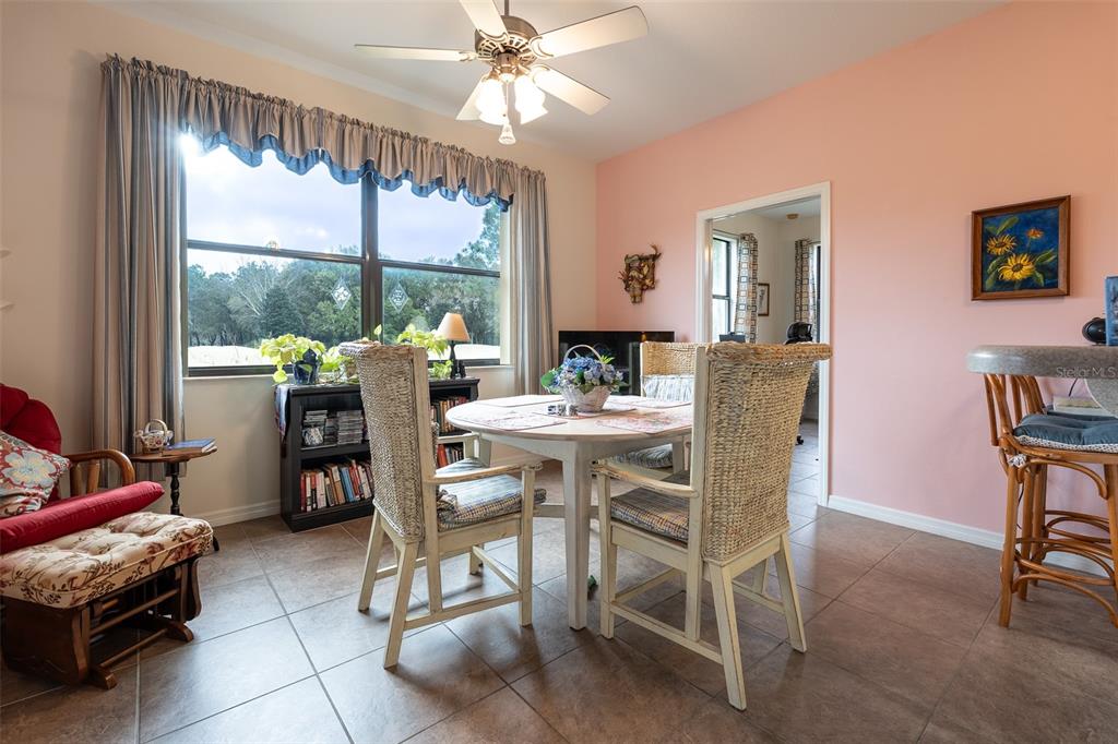 15969 Southwest 14th Avenue Road Ocala, FL 34473 - Photo 12 of 46 a view of a dining room with furniture large windows and wooden floor