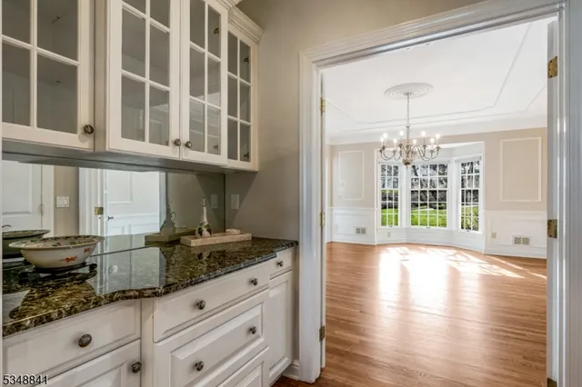 a kitchen with granite countertop a stove and a white cabinets