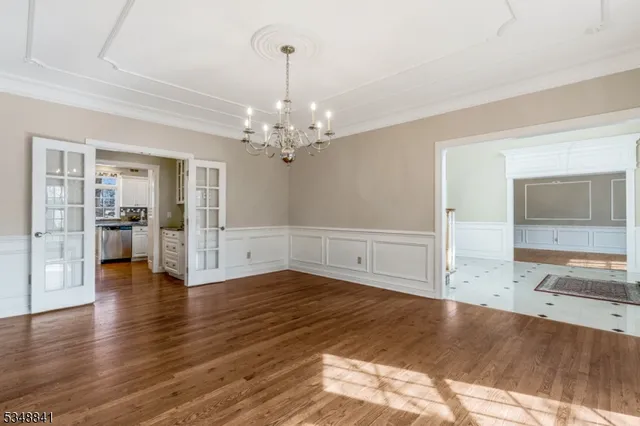 a view of a livingroom with wooden floor and kitchen space