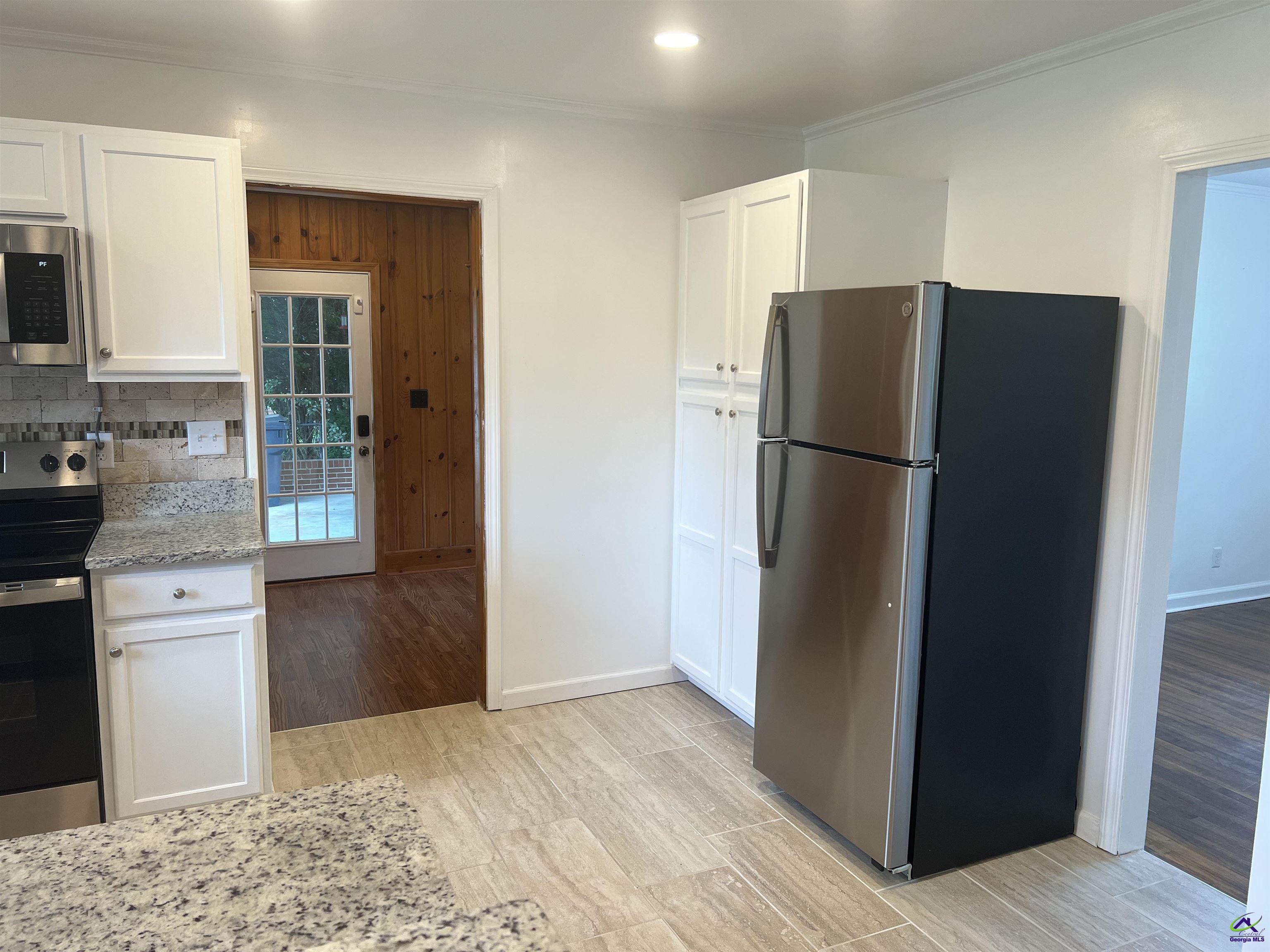 145 South 2nd Street Cochran, GA 31014 - Photo 5 of 24 a kitchen with a refrigerator and a stove top oven