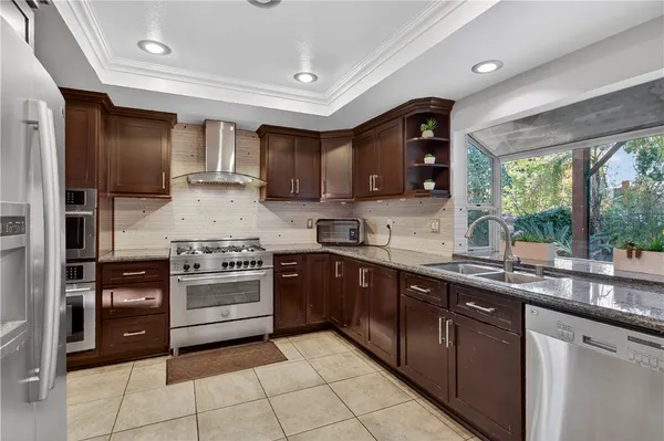 a kitchen with stainless steel appliances granite countertop a stove sink and cabinets