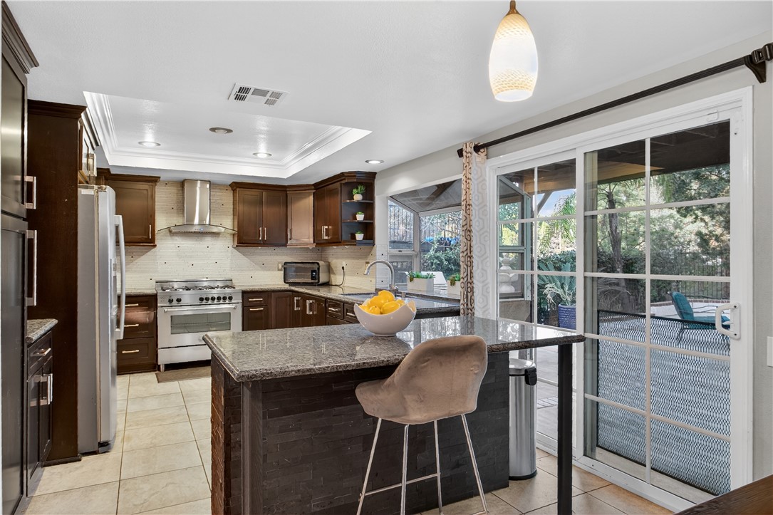 720 Ridgeview Road Anaheim Hills, CA 92807 - Photo 13 of 36 a kitchen with stainless steel appliances granite countertop a stove top oven a sink a dining table and chairs with wooden floor
