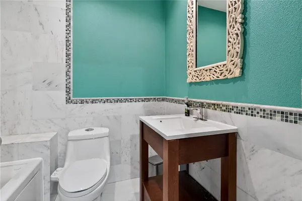 a bathroom with a toilet a sink and mirror