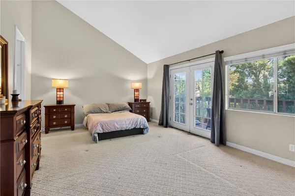 a spacious bedroom with a bed and large windows