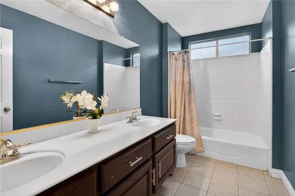 a bathroom with a granite countertop sink a toilet and shower
