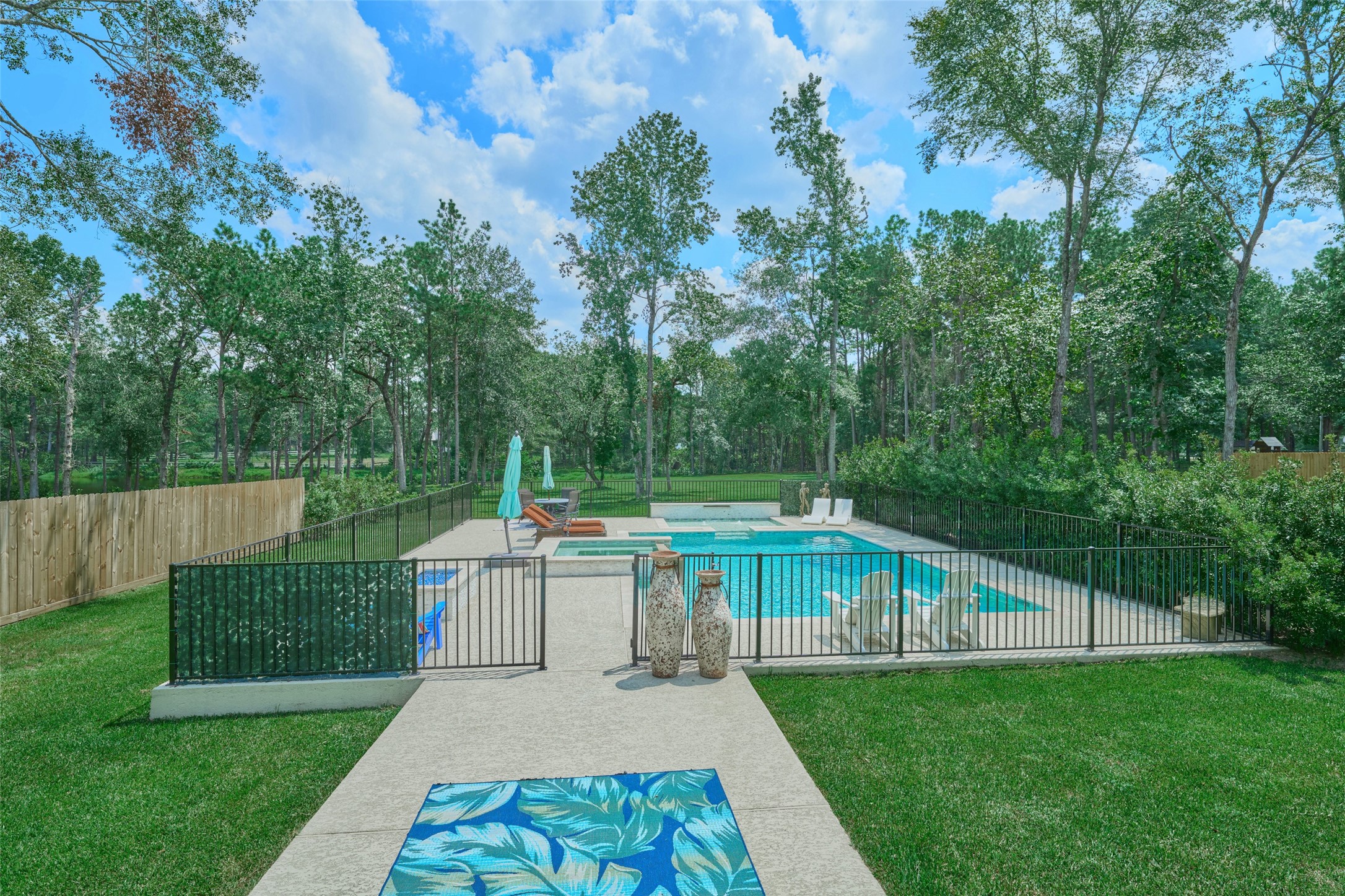 2218 Honea Egypt Road Magnolia, TX 77354 - Photo 15 of 50 Inviting outdoor oasis featuring a sparkling pool with serene woodland views, perfect for relaxation and entertaining.