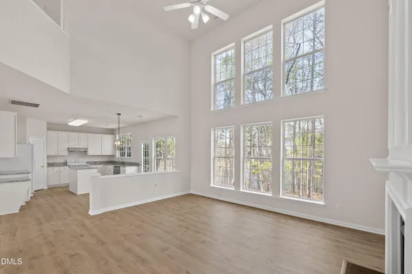 a kitchen with stainless steel appliances granite countertop a stove top oven a sink dishwasher and white cabinets with wooden floor