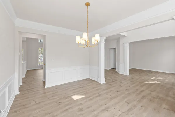 a view of an empty room with wooden floor fireplace and a window
