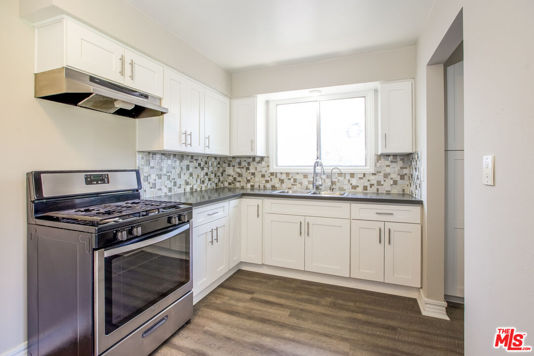 13014 Chestnut Avenue Rancho Cucamonga, CA 91739 - Photo 2 of 25 a kitchen with granite countertop wooden floor stainless steel appliances and a sink