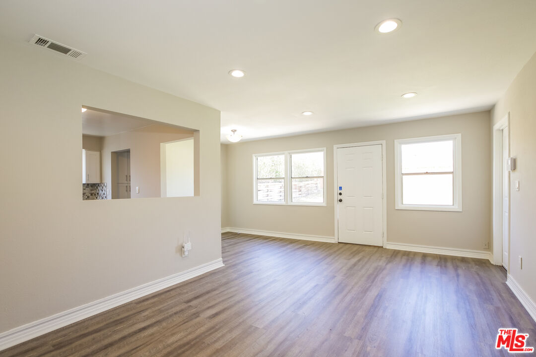 13014 Chestnut Avenue Rancho Cucamonga, CA 91739 - Photo 3 of 25 an empty room with wooden floor and windows