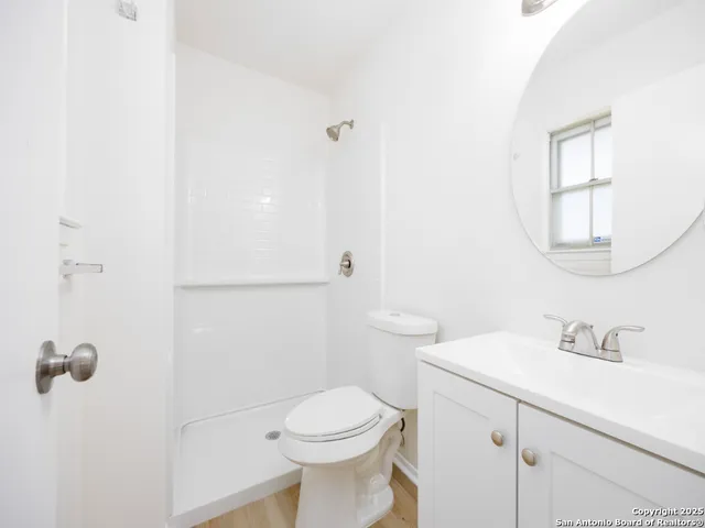 a bathroom with a sink a toilet and shower