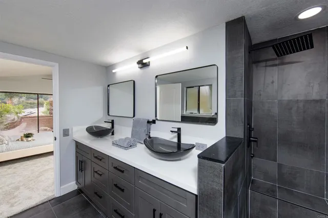 a bathroom with double vanity and a mirror