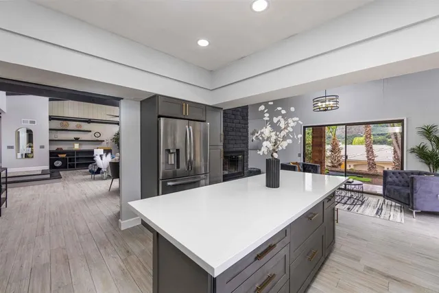 a living room with furniture a large window and wooden floor