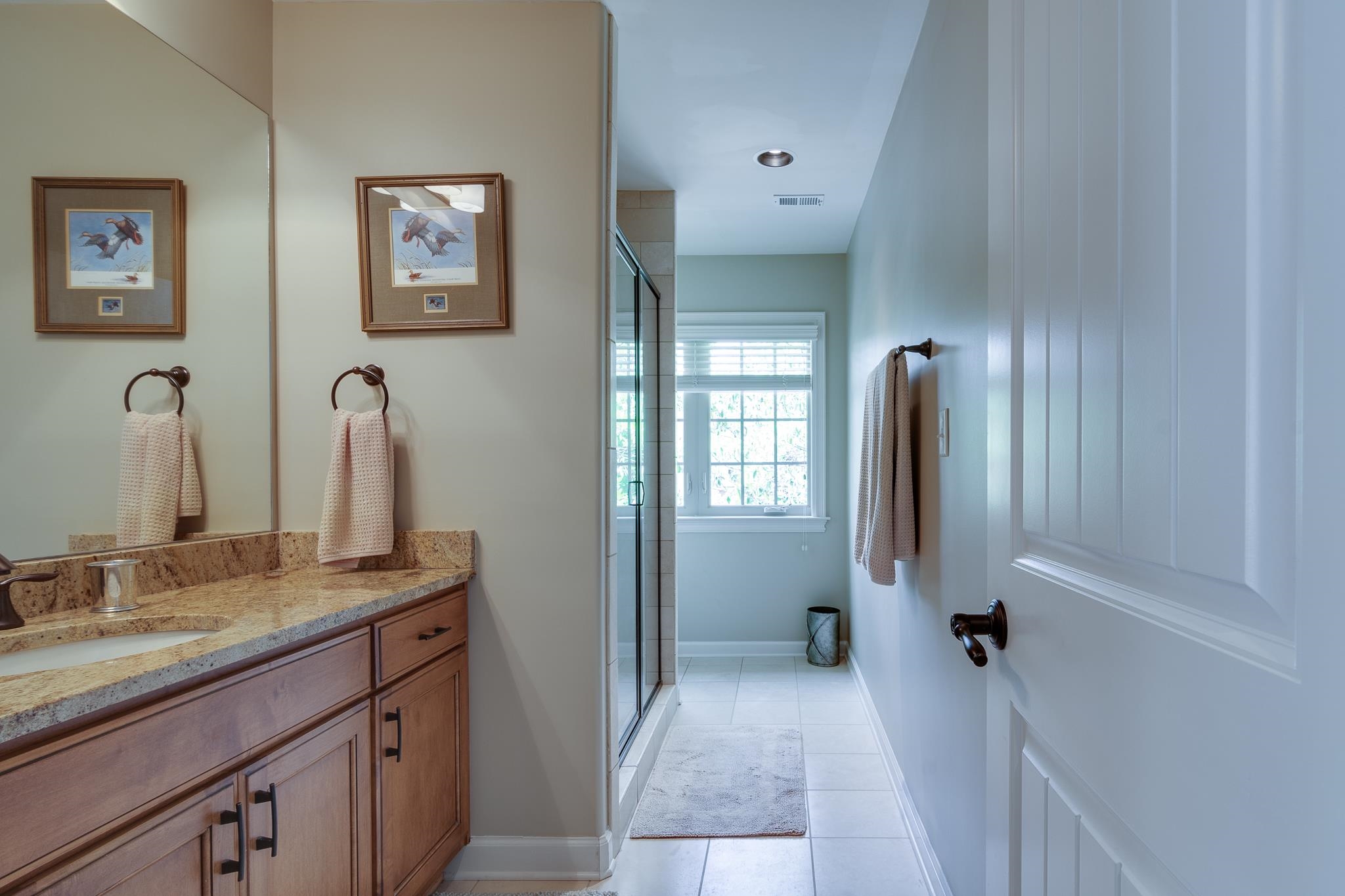 5245 Cole Road Memphis, TN 38120 - Photo 21 of 25 a bathroom with a granite countertop sink a mirror and a bathtub