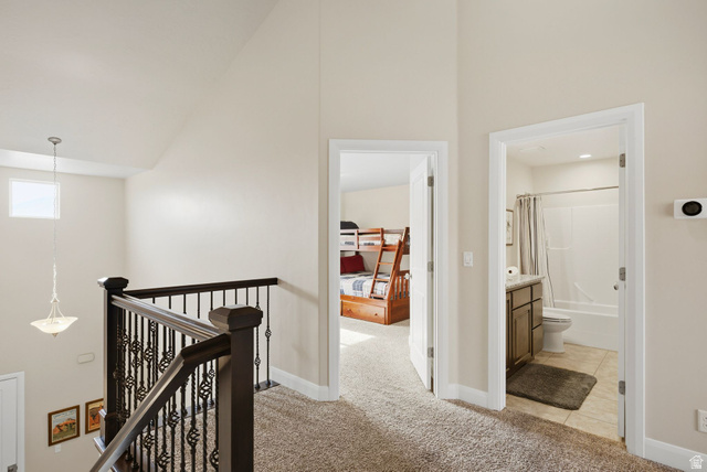 4269 Razor Drive Washington, UT 84780 - Photo 17 of 50 Hall with light carpet, high vaulted ceiling, and an upstairs landing