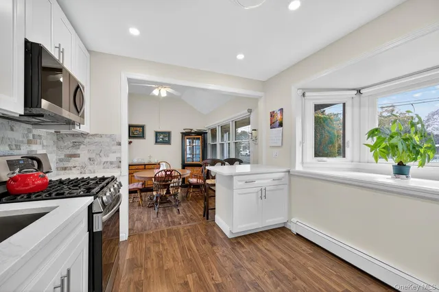 a kitchen with cabinets wooden floor and stainless steel appliances