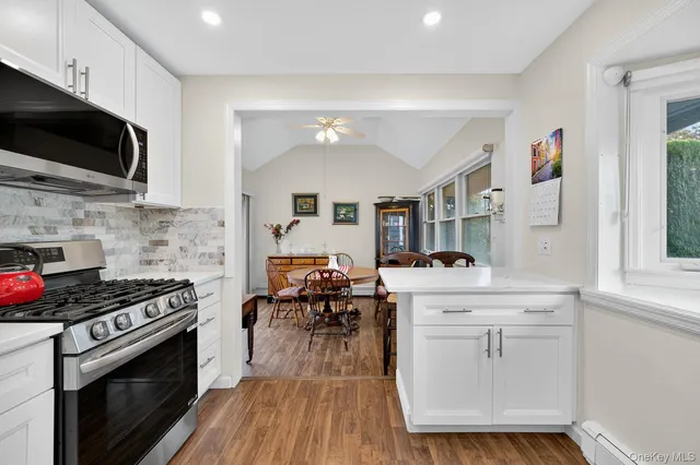 a kitchen with a stove a sink and wooden floor