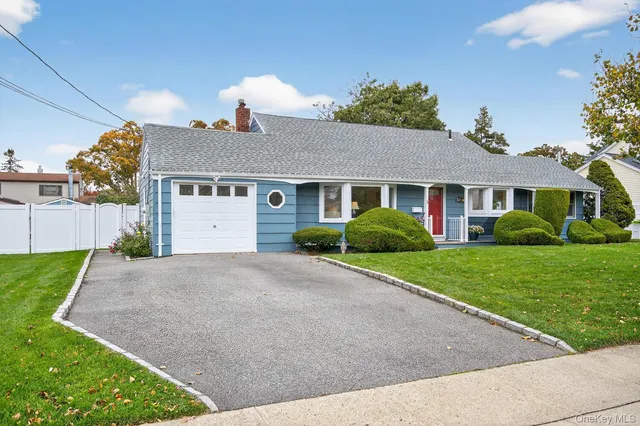 a front view of a house with a yard and potted plants