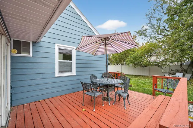 a view of a roof deck with table and chairs and wooden floor