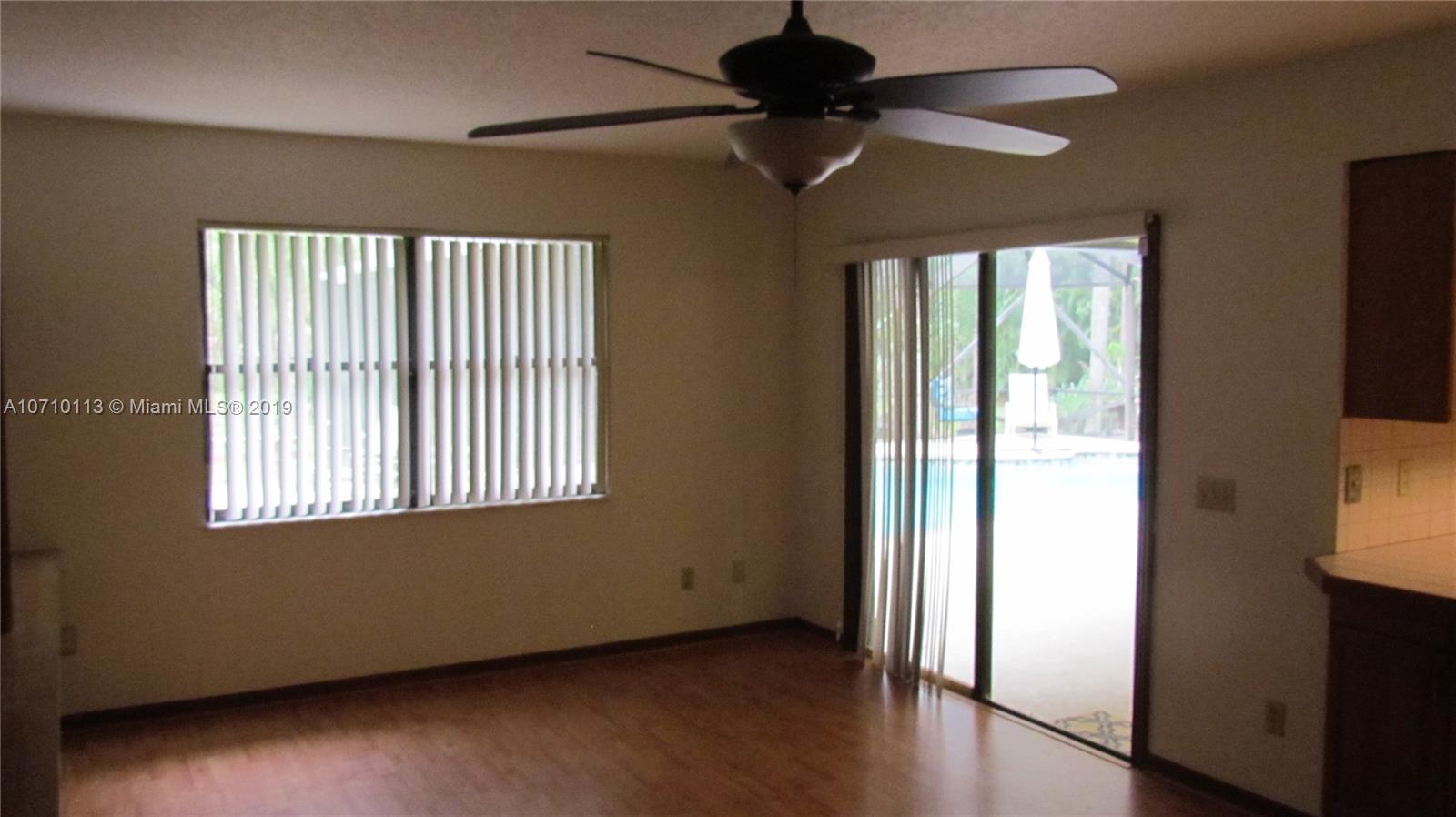 10825 Sandy Run Road Jupiter, FL 33478 - Photo 19 of 31 a view of an empty room with a window and wooden floor