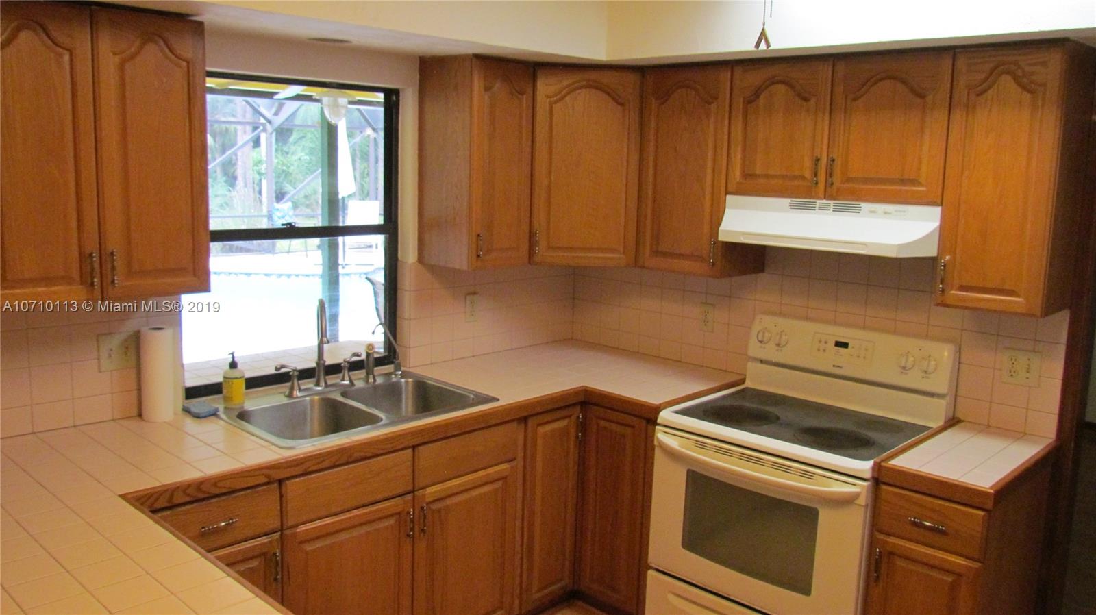 10825 Sandy Run Road Jupiter, FL 33478 - Photo 20 of 31 a kitchen that has a sink and a stove