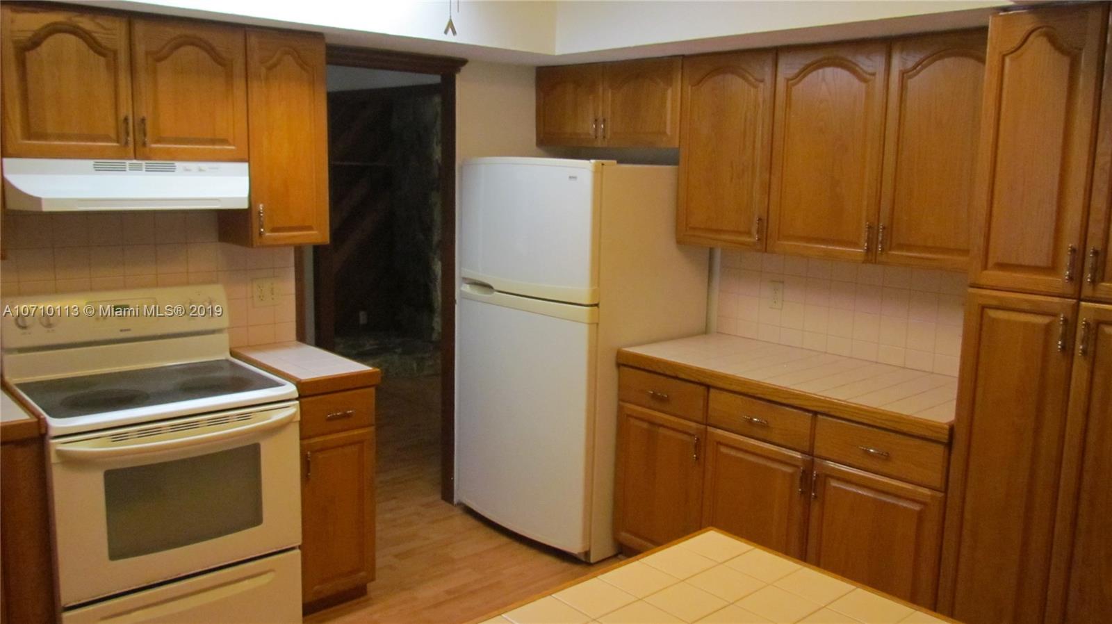 10825 Sandy Run Road Jupiter, FL 33478 - Photo 21 of 31 a kitchen with a refrigerator sink and cabinets