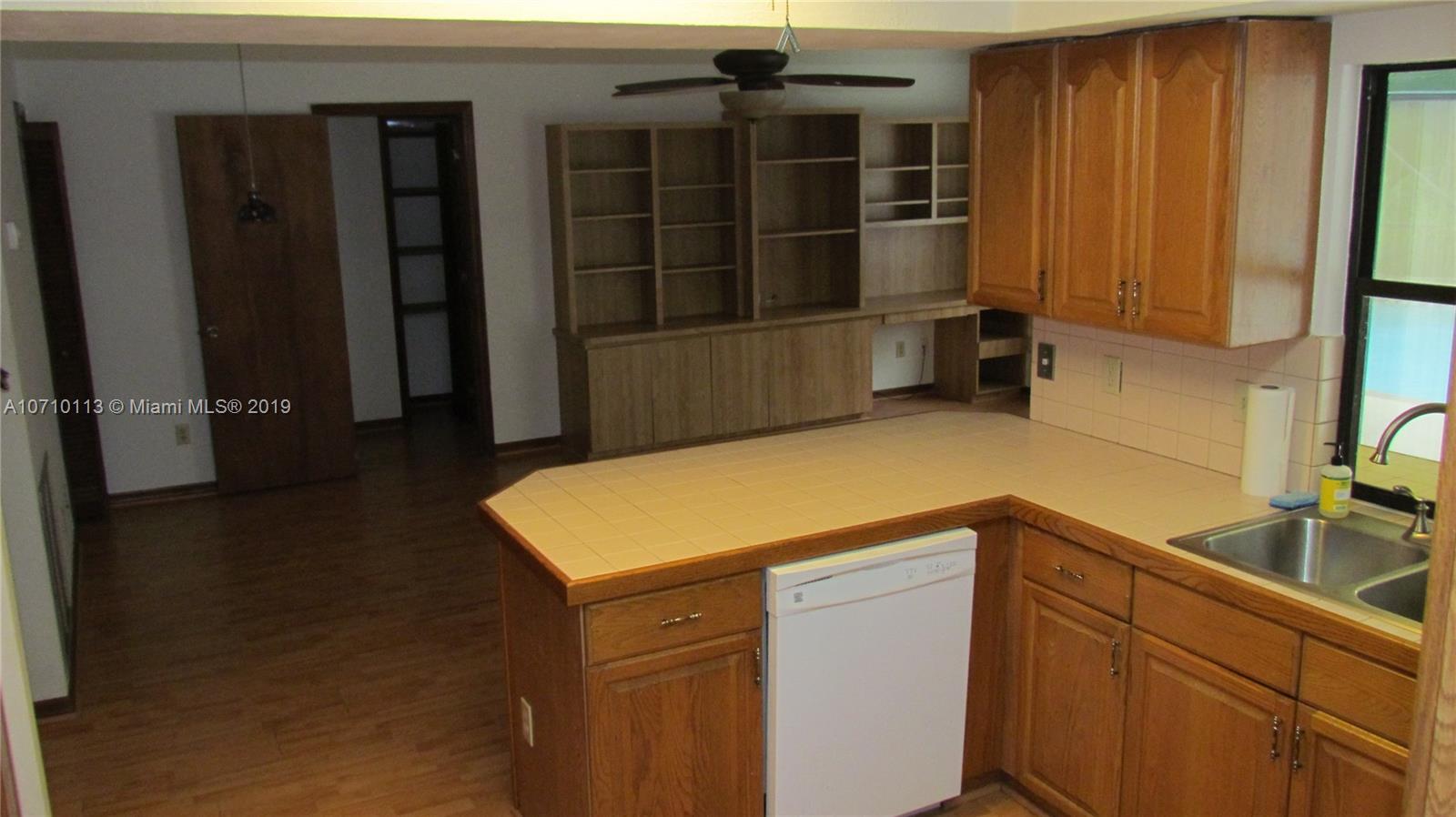 10825 Sandy Run Road Jupiter, FL 33478 - Photo 22 of 31 a kitchen with a refrigerator and cabinets
