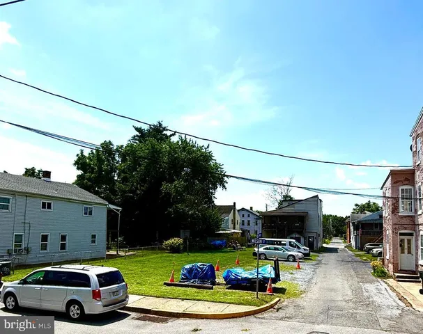 a front view of a building with cars parked