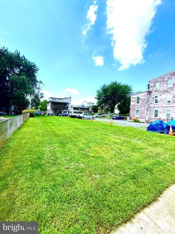 a view of a house with a big yard and potted plants