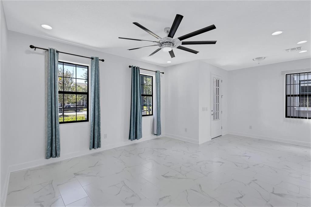 5830 Circa Fishhawk Boulevard Lithia, FL 33547 - Photo 13 of 37 a view of a livingroom with a ceiling fan & windows