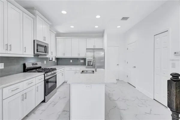 a kitchen with a sink a refrigerator a microwave and cabinets