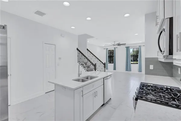 a kitchen with white cabinets and stainless steel appliances