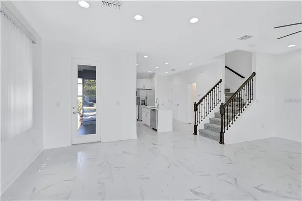 an empty room with white walls and stairs