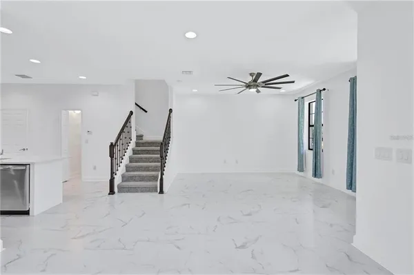 wooden floor in an empty room with a ceiling fan