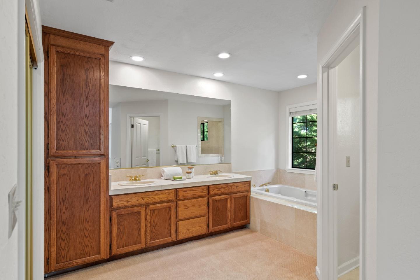 3017 Lopez Road Pebble Beach, CA 93953 - Photo 18 of 30 a spacious bathroom with a double vanity sink a large mirror and a bathtub