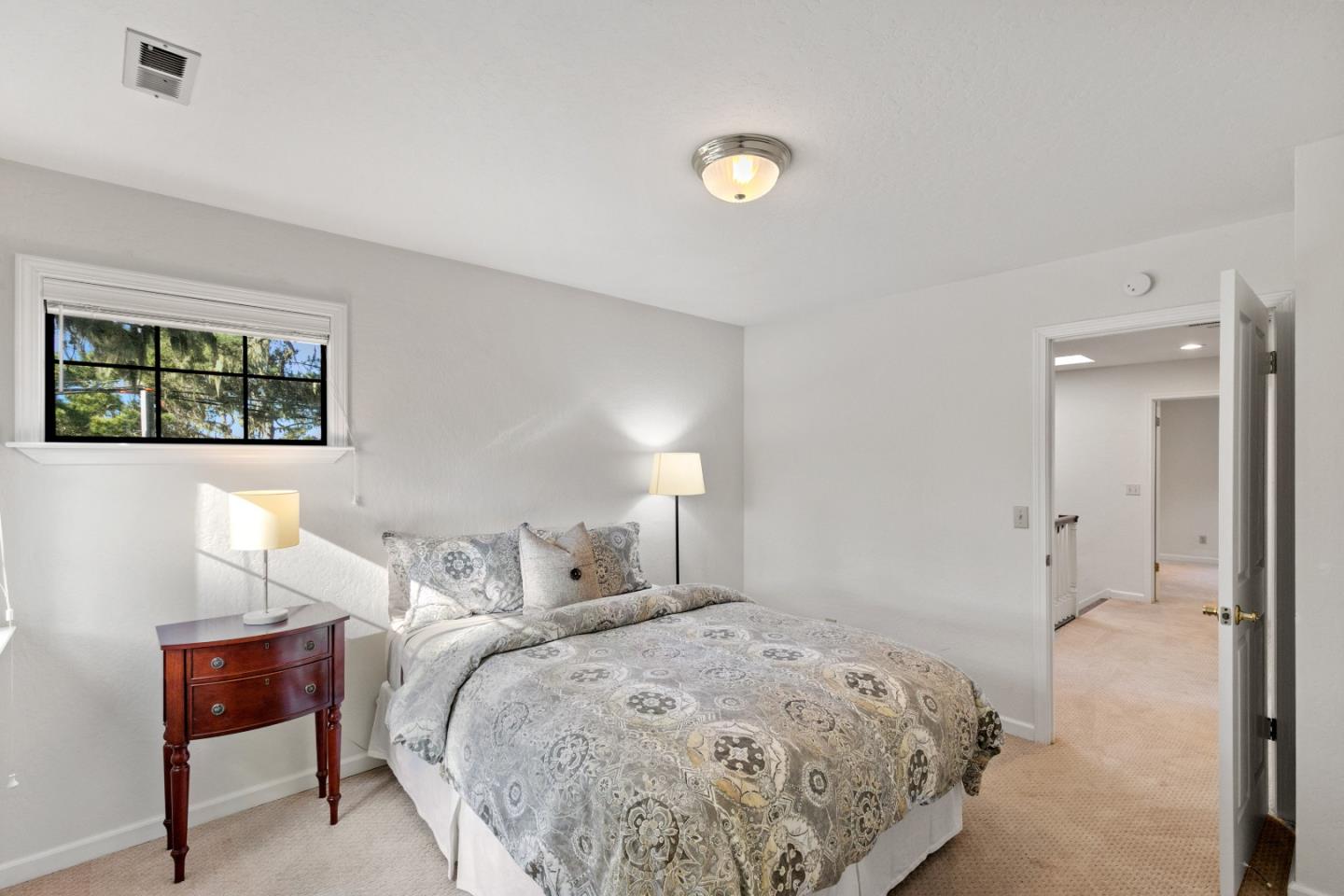 3017 Lopez Road Pebble Beach, CA 93953 - Photo 21 of 30 a bedroom with a bed and a lamp next to a window
