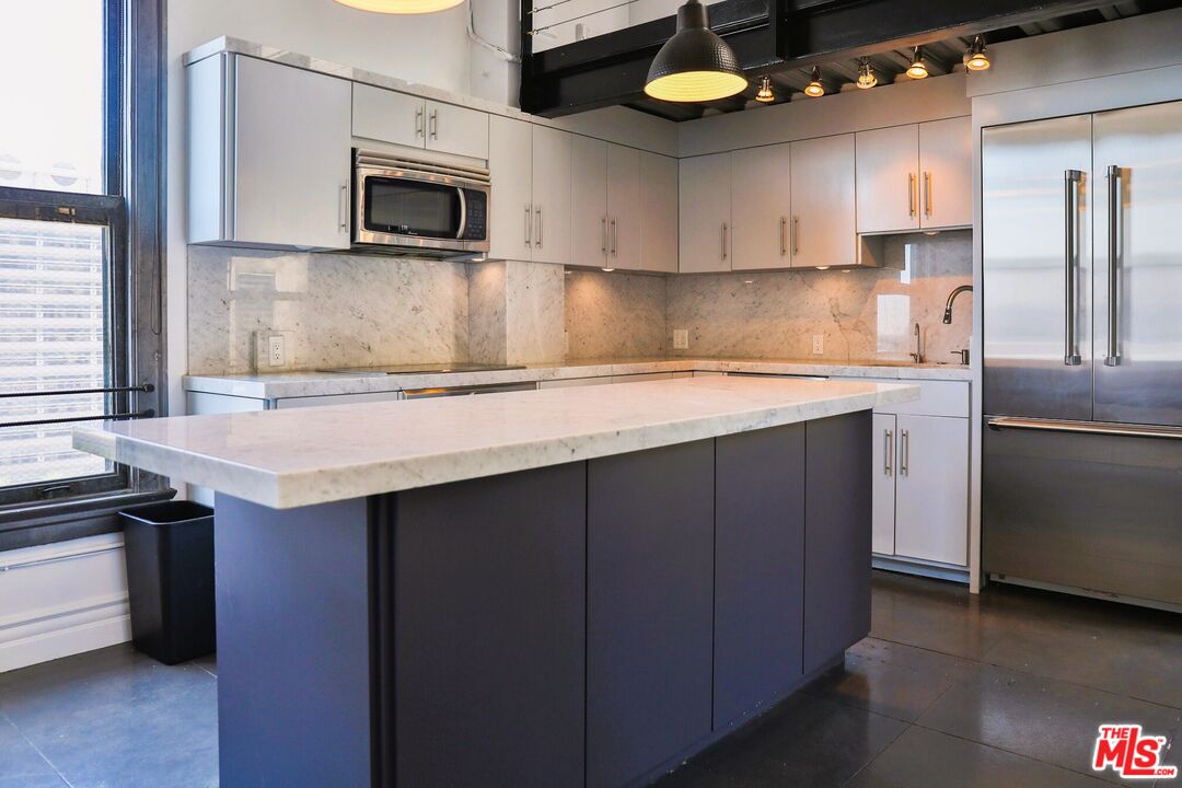 108 West 2nd Street, Unit PH1007 Los Angeles, CA 90012 - Photo 14 of 34 a kitchen with stainless steel appliances a stove microwave and sink