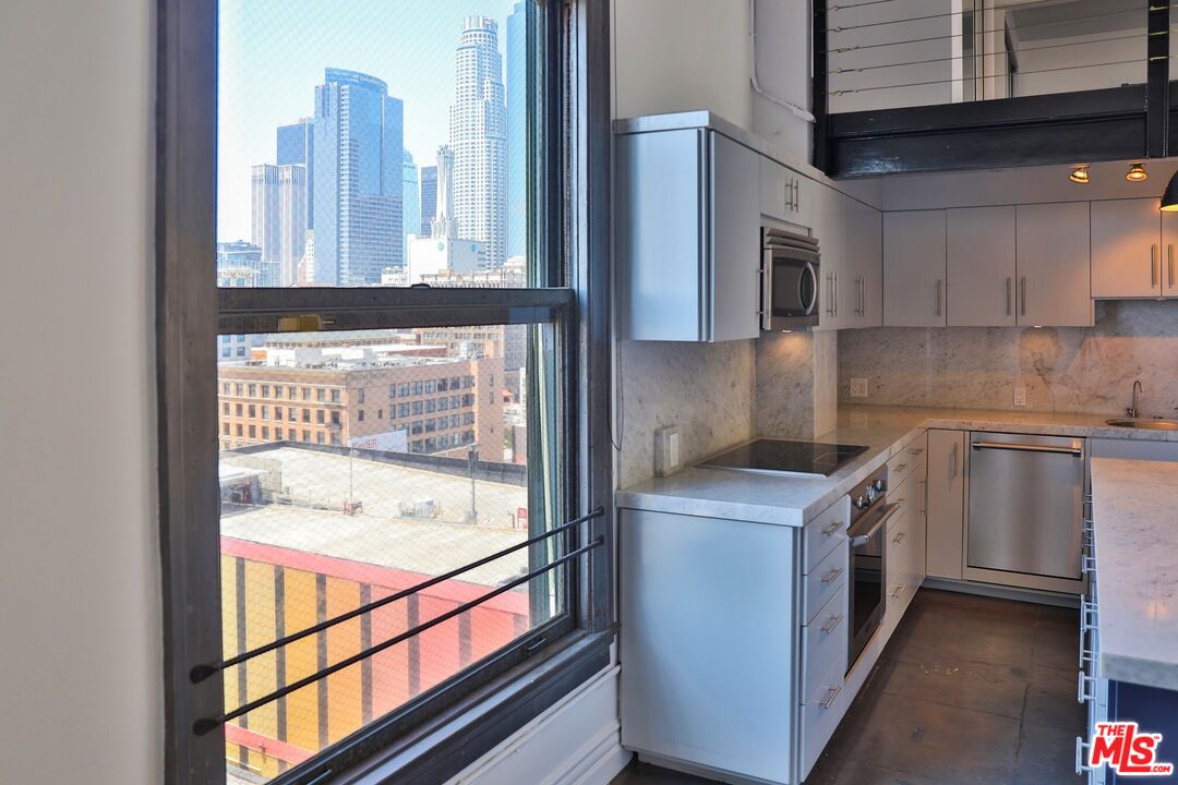 108 West 2nd Street, Unit PH1007 Los Angeles, CA 90012 - Photo 15 of 34 a kitchen with a sink and a stove