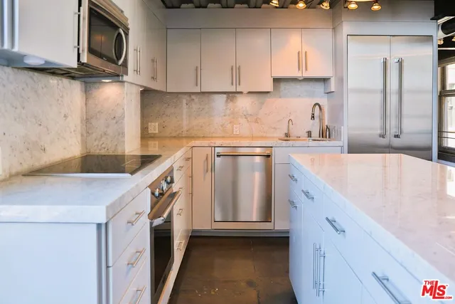 a kitchen with stainless steel appliances granite countertop a sink and a stove