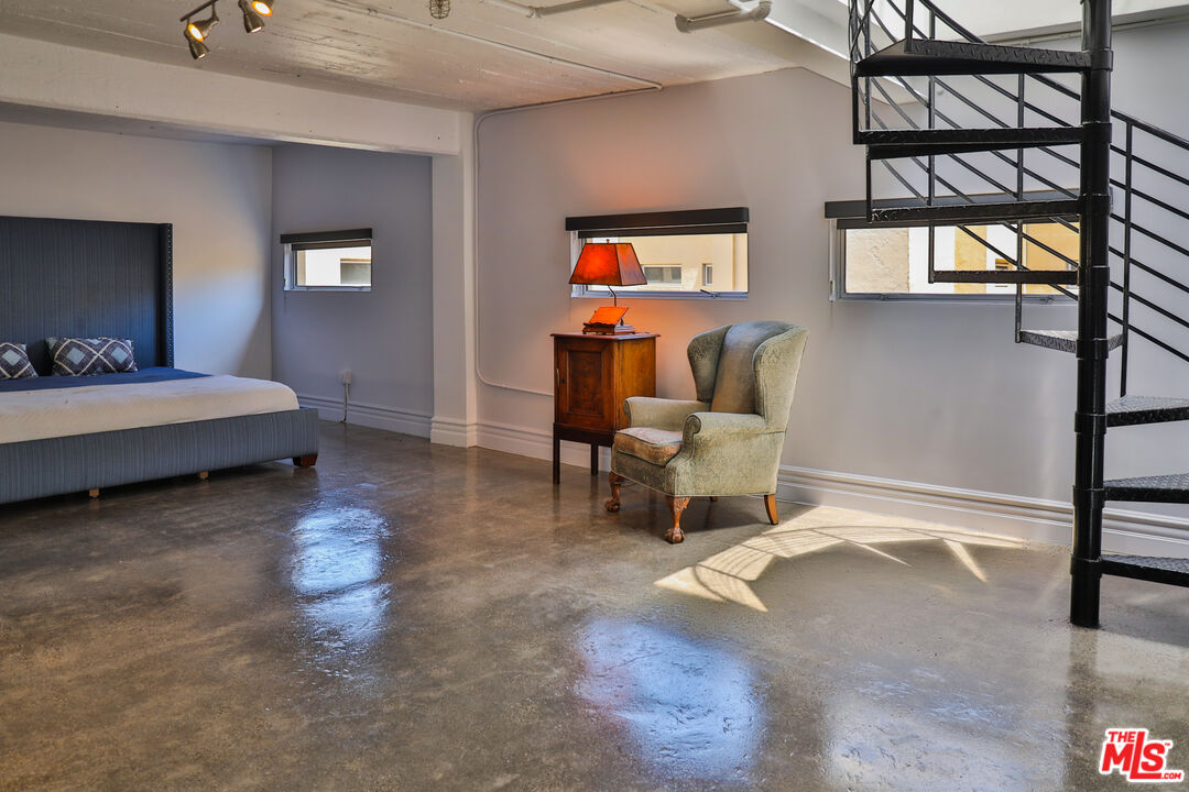 108 West 2nd Street, Unit PH1007 Los Angeles, CA 90012 - Photo 24 of 34 a living room with a bed furniture and a window