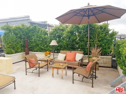 a view of a patio with a table and chairs under an umbrella