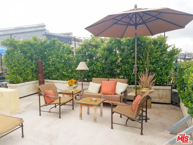a view of a patio with a table and chairs under an umbrella