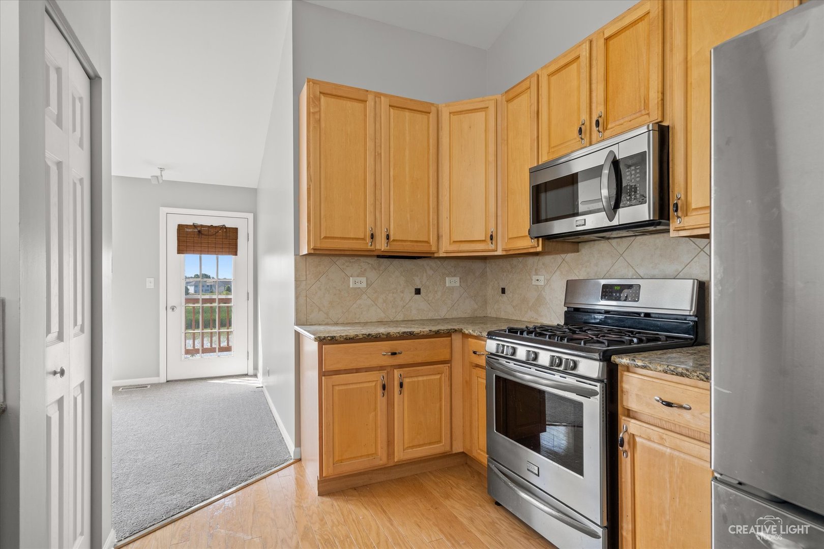 2467 Golf Ridge Circle, Unit 2467 Naperville, IL 60563 - Photo 9 of 25 a kitchen with stainless steel appliances granite countertop a stove a microwave and a refrigerator